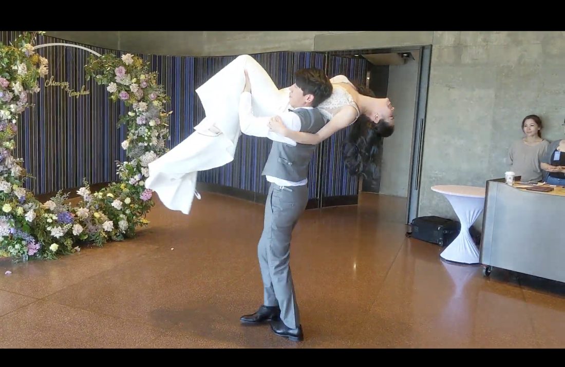 A couple performing a dramatic first-dance lift